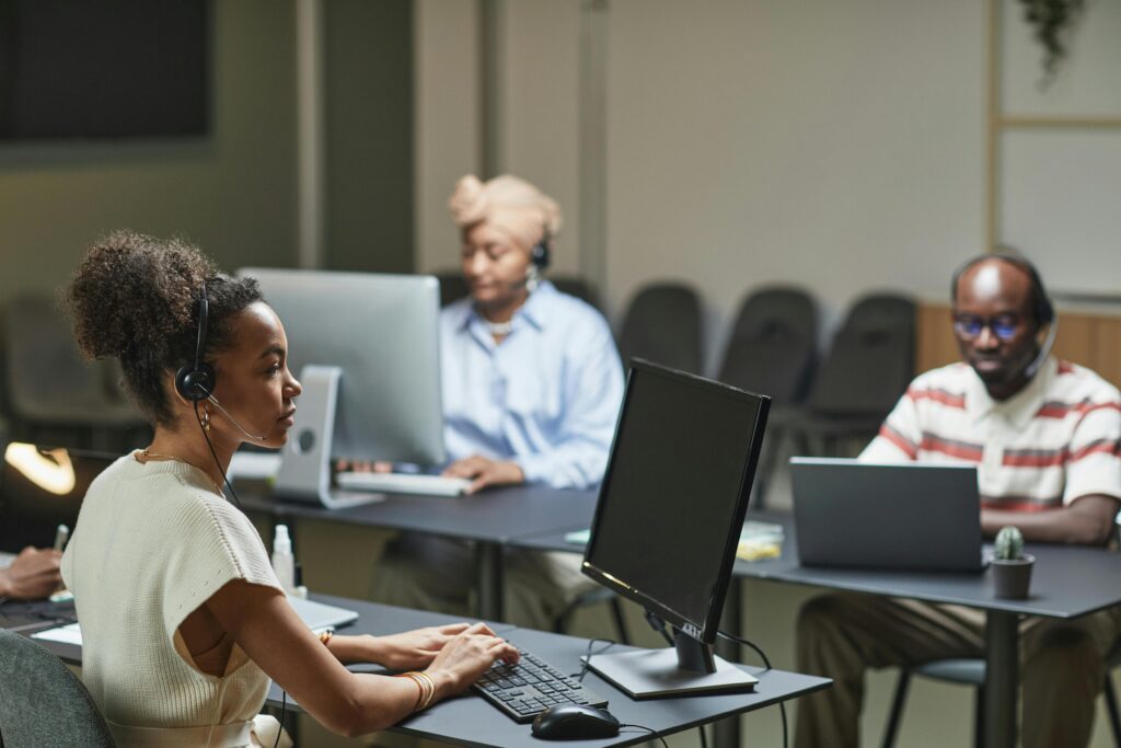 Three call center agents at work, focused and professional in a modern office environment.